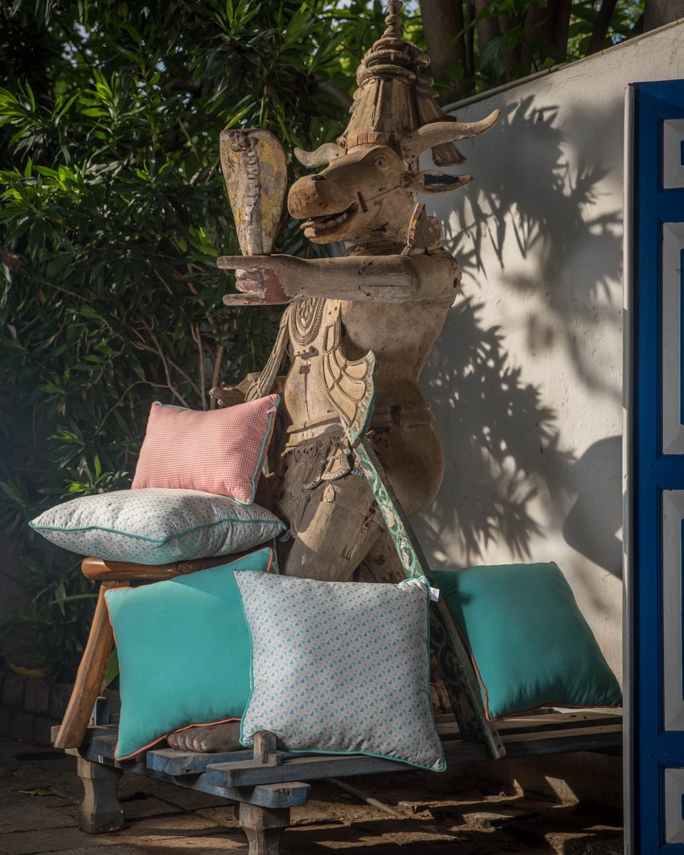 Cushion set styled on a carved bench, pink and teal