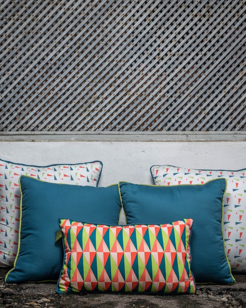 Cushion set — teal and print cushions grouped against a white wall