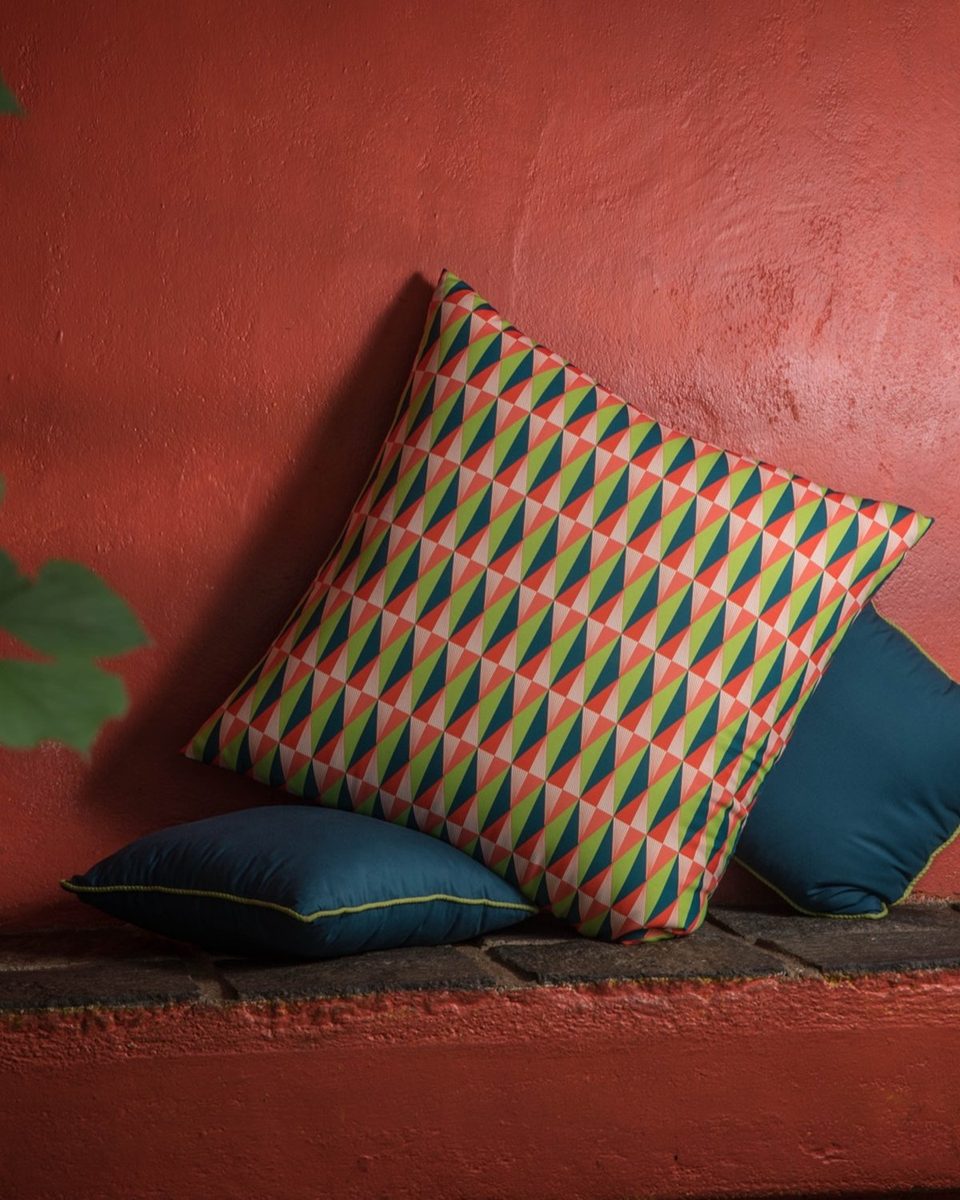 Christmas print floor seater cushions against a terracotta wall