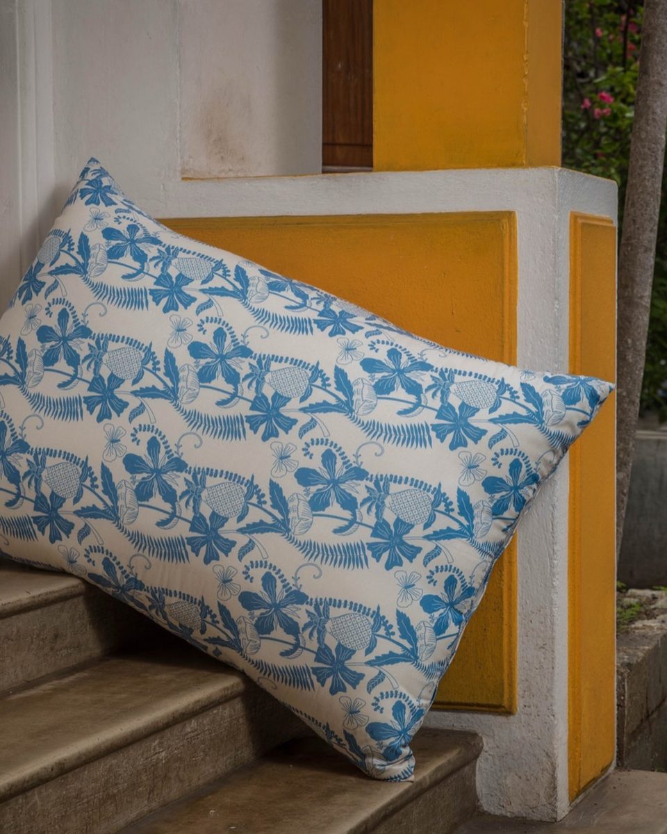 Tropical blue botanical print cushion on a doorstep