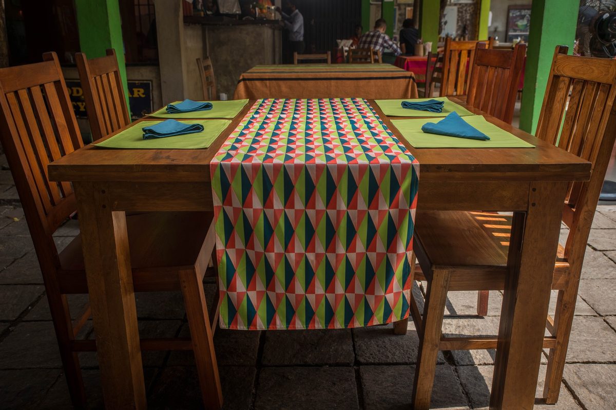 Geometric table runner with green placemats and teal napkins