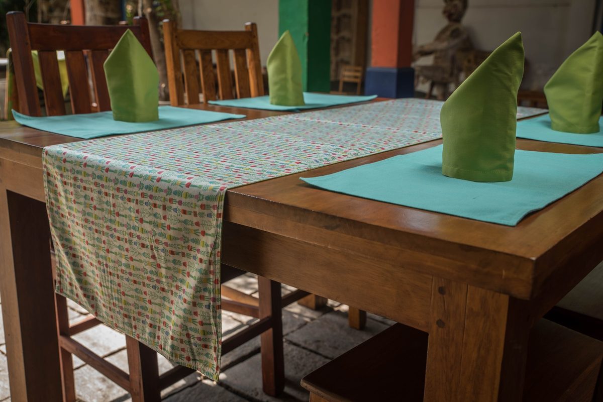 Botanical table runner with teal placemats and green napkins