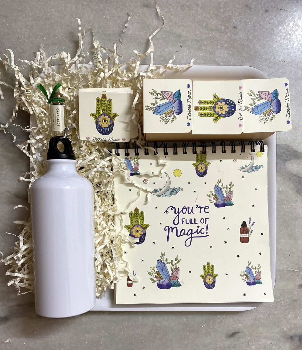 A packed gift box — bottle, notebook and coasters