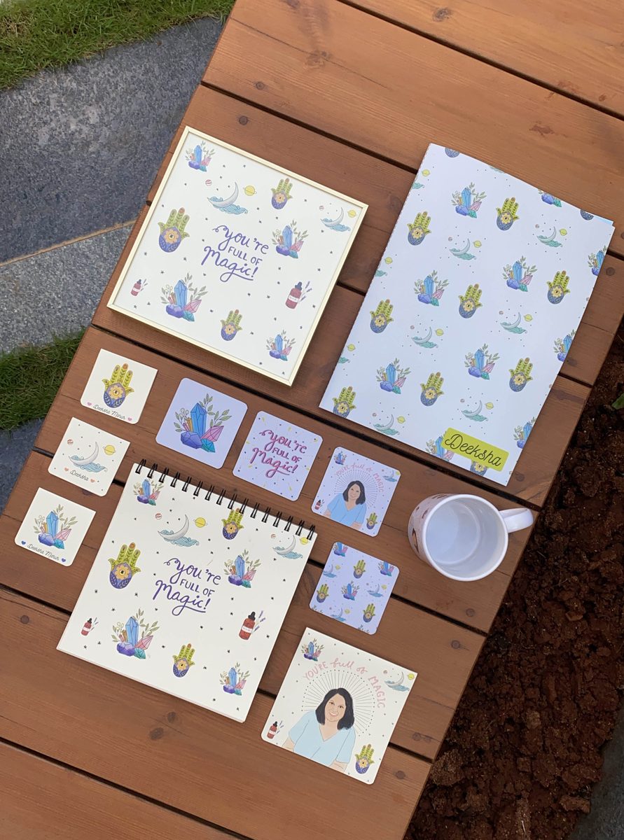 Notebook, coasters and mug laid out on wood
